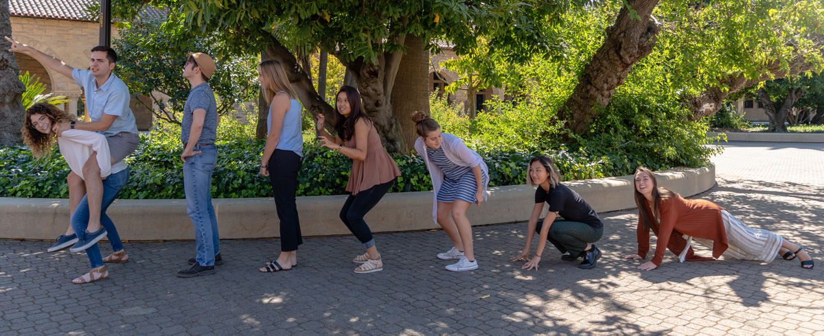 Course Associates pose as evolution of mankind
