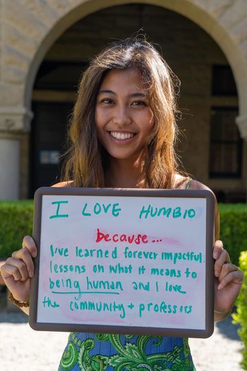 Students holds a white board that reads "I love HumBio because I've learned forever impactful lessons on what it means to being human and I love the community and professors"