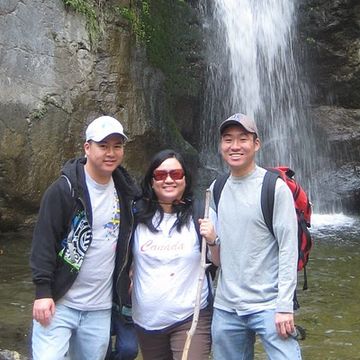 Miranda Ow posing with her 2 sons in front of a waterfall