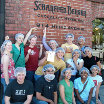 Meera Subash poses in front of Sharfenberger Chocolate sign with classmates