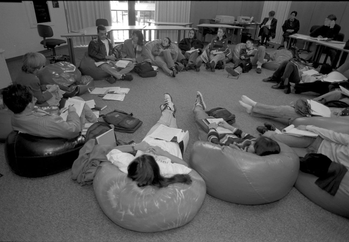 Students talk and sit in a circle on beanbags 